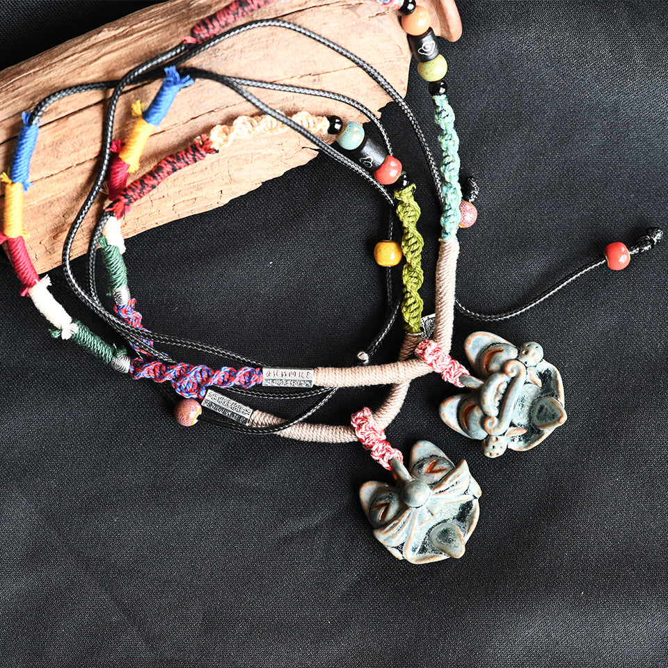Verdigris Spirit ceramic WaMao necklace by VividAion, featuring mythic Tile Cat guardian charm and braided cord, handmade with verdigris glaze.