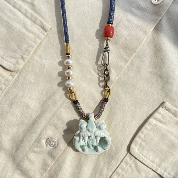 Sky-blue handcrafted ceramic WaMao pendant necklace by VividAion Liang Yu, inspired by Tile Cat guardianship and tranquility.