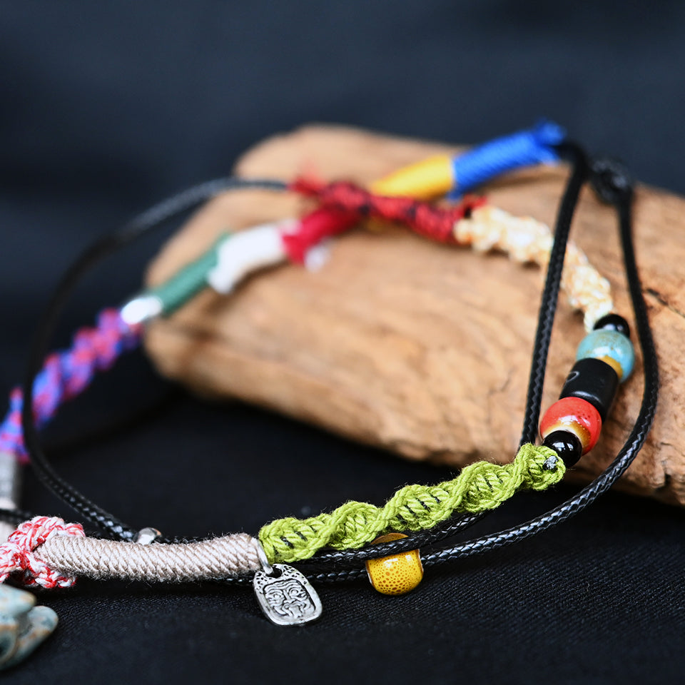 Close-up of VividAion braided cord necklace showing detailed handwoven texture, resin beads and metal accents.
