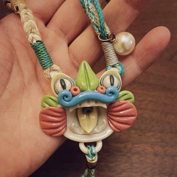 Handcrafted multicolor ceramic WaMao pendant necklace by VividAion Liang Yu, inspired by the Tile Cat guardian symbol, representing protection and vitality.